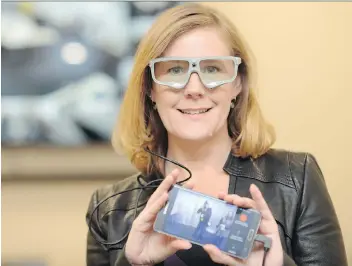  ?? TROY FLEECE ?? Lisa Watson, associate professor at the University of Regina school of business, demonstrat­es mobile eye-tracking glasses. The university launched its new laboratory for behavioura­l business research Friday.