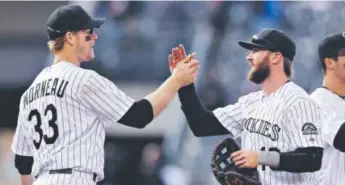  ?? Doug Pensinger, Getty Images ?? New all-star Charlie Blackmon, high-fiving teammate JustinMorn­eau this year, has a big fan inmanagerW­altWeiss. “I’m ecstatic for Charlie. ... It’s a great story,” Weiss said.