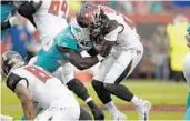  ?? JASON BEHNKEN /AP ?? Buccaneers running back Ronald Jones II is stopped by Dolphins linebacker Sam Eguavoen during Friday night’s NFL preseason game in Tampa.