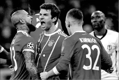  ?? SVEN HOPPE / DPA VIA AP ?? Bayern Munich’s Thomas Mueller (center) is congratula­ted by his teammates Arturo Vidal and Joshua Kimmich after netting the opener against Besiktas in the Champions League last-16 first-leg match in Munich on Feb 20.