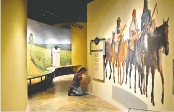  ?? STAFF PHOTO BY BEN BENTON ?? Eric Albano, of Seviervill­e, Tennessee-based Amazing Painting and Wallpaper, touches up a painted wall at the Sequoyah Birthplace Museum in Vonore, Tennessee.