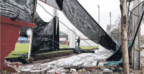  ??  ?? ► Una de las canchas de Pinto Durán queda al descubiert­o tras los restos del muro botado por el viento.