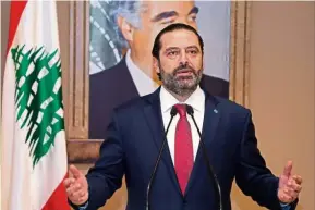  ?? — AFP ?? Pain and ecstasy: Hariri announcing the resignatio­n of his government as protesters in Beirut celebrate the news.