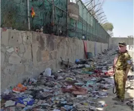  ?? AFP VIA GETTY IMAGES ?? A Taliban fighter stands guard at the site of the suicide bombing that killed scores of people, including 13 U.S. troops, at Kabul airport on Aug. 27.