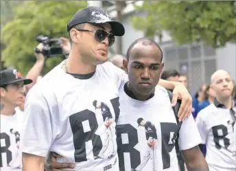  ?? Rob Foldy/Getty Images ?? Giancarlo Stanton leans on Marcell Ozuna for support as they return to the stadium Wednesday after surroundin­g the hearse carrying Miami Marlins pitcher Jose Fernandez.