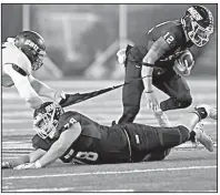  ?? AP/LEE LUTHER JR. ?? Mount Union’s D’Angelo Fulford (12) runs as a Mary Hardin-Baylor defender hangs on to his jersey during the first half of the Division III championsh­ip Friday in Salem, Va. Mount Union won 12-0.