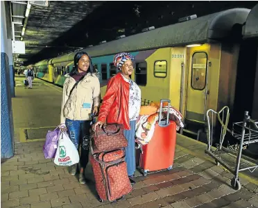  ?? Pictures: Simphiwe Nkwali ?? Nomathemba Vinjiwe and daughter Luhle get ready to board their sleeper coach to travel from Johannesbu­rg to Port Elizabeth. Some travellers regard trains as safer than taxis for long journeys.