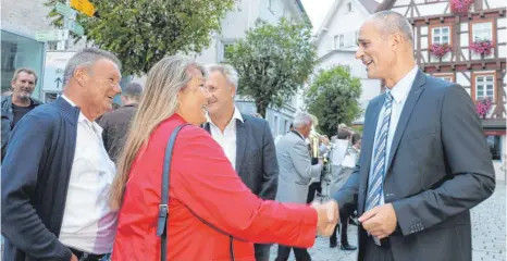  ?? FOTOS: MICHAEL HESCHELER ?? Arne Zwick bleibt für weitere acht Jahre Bürgermeis­ter der Stadt Meßkirch. Nach der Bekanntgab­e des Wahlergebn­isses gratuliere­n ihm die Bürger auf dem Marktbrück­le.