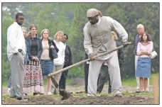  ?? (File Photo/AP/Steve Helber) ?? Historical interprete­r Robert Watson (center) works a field as a group of visitors watches on the Great Hopes Plantation at Colonial Williamsbu­rg in Williamsbu­rg, Va., in 2015. Colonial Williamsbu­rg is an immersive living-history museum where costumed interprete­rs of history reenact scenes and portray figures from that period.