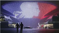  ??  ?? SHANGHAI: A building near the site of the 2010 Shanghai World Expo is lit up in the colors of the French national flag to mourn for the victims killed in Friday’s attacks in Paris, at a district of Shanghai, China Saturday. —AP