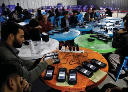  ??  ?? Afghan election commission workers transfer data from biometric devices to the main server in Kabul, October 2019. Photograph: Mohammad Ismail/Reuters