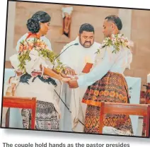  ?? ?? The couple hold hands as the pastor presides over their wedding ceremony.