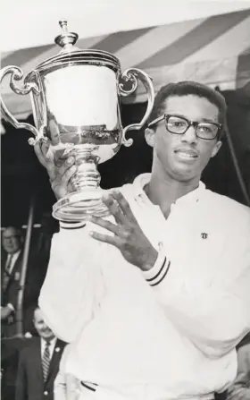  ?? New York Post Archives 1968 via Getty Images ?? A 25-year-old Arthur Ashe proudly hoists the winner’s trophy at the U.S. Open, his first major championsh­ip, on Sept. 10, 1968, in Forest Hills, N.Y.