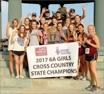  ?? Graham Thomas/Siloam Sunday ?? The Siloam Springs girls cross country team pose with the Class 6A state championsh­ip trophy after winning the Class 6A State Championsh­ip for the fourth straight year Friday at Oaklawn Park in Hot Springs.