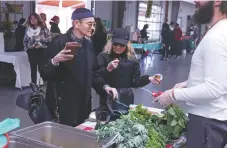  ?? DANIELLE PROKOP/THE NEW MEXICAN ?? Suzanne Klotz, right, and her mother, Winnie, pick up radishes from Khalsa Family Farms on Saturday at the Santa Fe Farmers Market. ‘I’m thrilled to see so many people out and about,’ Suzanne Klotz said.