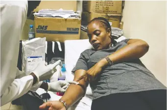  ??  ?? Sylvia Nguma donates blood in hopes of helping a baby in desperate need of a blood transfusio­n.