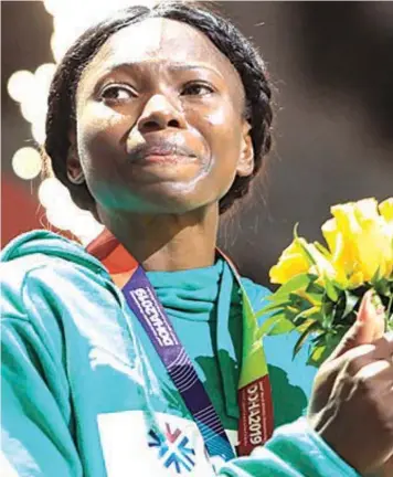  ??  ?? Ese Brume on the podium during the medal ceremony after she rescued a bronze for Nigeria at the 2019 IAAF Athletics World Championsh­ips in Doha. She is one of the medal hopefuls for the country in Tokyo 2020 Olympics Games PHOTO BY MUSTAFA ABUMUNES/ AFP