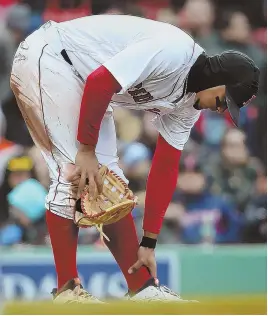  ?? STAFF PHOTO BY NANCY LANE ?? WHAT A PAIN: Red Sox shortstop Xander Bogaerts reaches down to his injured left foot after sliding into the Rays dugout in the seventh inning of yesterday’s 8-7 victory at Fenway Park.