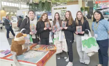  ?? ?? Visitors from Poland with STB official Diana Gaban (right) displaying the multilingu­al Sabah brochure at the STB exhibition booth.