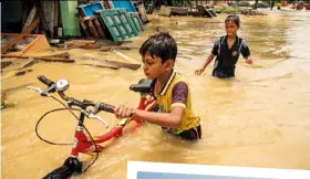  ??  ?? LEFT: A man is pulled from a collapsed sixstorey building in Mumbai. ABOVE: Boys wade through high water in Howrah, India. RIGHT: Dev Kuma Sada guides the body of his nephew through the waters in the Koshi river in Nepal. The boy died from sickness caused by exposure to rainfall. BELOW: Nepali residents stay afloat in the Birgunj Parsa, south of Kathmandu.