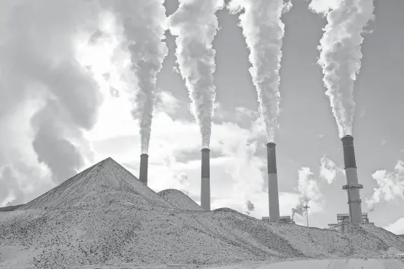  ?? PHOTOS BY JAY CALDERON/USA TODAY NETWORK FILE ?? Behind piles of coal covered in snow, stacks fill the sky with steam at PacifiCorp’s Jim Bridger coal plant in Wyoming.