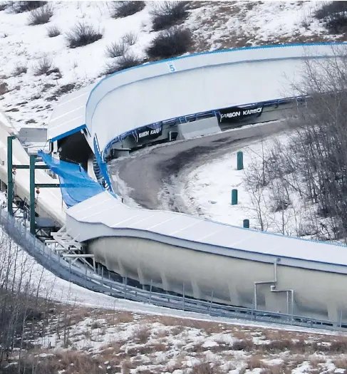  ?? LARRY MACDOUGAL / THE CANADIAN PRESS FILES ?? A tarp covers the intersecti­on of the bobsled and luge tracks at Canada Olympic Park in Calgary, where two teens died and six others were hurt after going on an early-morning joyride down the closed course in February. One of the teens, Caleb Hettinga,...