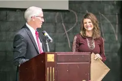  ?? Staff photo by Kayleigh Moreland ?? Art teacher Nicole Brisco smiles on stage alongside state Rep. Gary VanDeaver after being awarded a plaque Wednesday at the Pleasant Grove High School cafeteria. A holiday luncheon was held to recognize Brisco for winning a Texas Humanities Award.