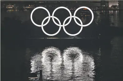  ?? Kazuhiro Nogi / AFP via Getty Images ?? A lighted display of the Olympic rings is displayed off the shore of Odaiba Marine Park in Tokyo in January.