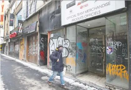  ?? RYAN REMIORZ/THE CANADIAN PRESS ?? A pedestrian walks past a row of closed storefront­s as the COVID-19 pandemic continues to take its toll on businesses in downtown Montreal. A new Quebec-centric retail website is in the works to give provincial­ly owned merchants a boost.