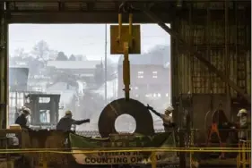  ?? Alexandra Wimley/Post-Gazette ?? Workers prepare a coil of steel for transport last month at the JSW Steel mill in Mingo Junction, Ohio.