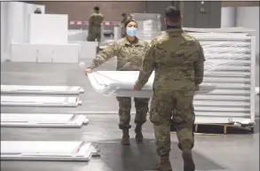  ?? H John Voorhees III / Hearst Connecticu­t Media ?? Spc. Samantha Pozo, left, of Danbury, and Spc. Daniel Lovallo, of West Haven, were part of the Connecticu­t National Guard setting up a field hospital at the Connecticu­t Convention Center in Hartford. Hartford HealthCare will be operating the site.