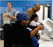  ?? ARVIN TEMKAR/ARVIN.TEMKAR@AJC.COM ?? Consolidat­ion assistants and supervisor­s for the Gwinnett County Voter Registrati­on and Elections Office process absentee ballots on May 23.