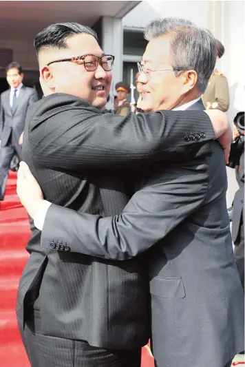  ??  ?? Kim Jong-un bids farewell to Moon Jae-in after finishing their unexpected two-hour meeting on the demilitari­sed border