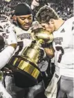  ?? Bruce Newman / Oxford (Miss.) Eagle ?? The Bulldogs’ Elgton Jenkins (left) and QB Nick Fitzgerald kiss the Golden Egg.
