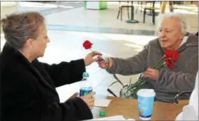  ?? TAWANA ROBERTS — THE NEWS-HERALD ?? Atria Newell Creek resident Andriana Bartok, who is 89, passes out carnations for Valentine’s Day at Great Lakes Mall in Mentor on Feb. 12.