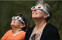  ?? BILL UHRICH — MEDIANEWS GROUP ?? Lisa Haggerty of Reading, left, and Crystal Seitz of Oley watch the eclipse on April 8 at the Reading Public Museum.