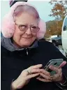  ??  ?? ■ Diana Maxwell is well prepared for Atlanta’s Christmas parade. She’s comfy with warm ear muffs and a cool cellphone.