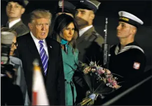  ?? The Associated Press ?? FOREIGN TRIP: President Trump, right and the first lady Melania Trump walk past the honor guards as they arrive Wednesday to Warsaw, Poland. President Donald Trump is back to Europe hoping to receive a friendly welcome in Poland despite lingering...