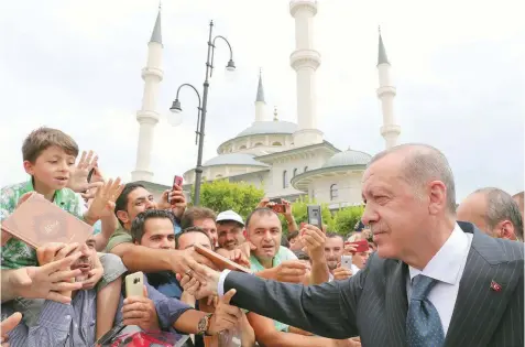  ?? — Reuters ?? Turkish President Tayyip Erdogan greets his supporters as he leaves from a mosque following the Friday prayers in Ankara.