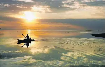  ?? RED HUBER/STAFF PHOTOGRAPH­ER ?? Nick Larson of Orlando paddles his kayak near dawn while fishing on Mosquito Lagoon at Merritt Island National Wildlife Refuge, one of columnist Scott Maxwell’s 101 things to love about Central Florida.