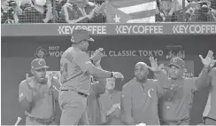  ?? SHIZUO KAMBAYASHI THE ASSOCIATED PRESS ?? Cuba’s Alfredo Despaigne, second from left, celebrates with teammates after hitting a solo home run against Japan’s pitcher, Takahiro Norimoto, in the seventh inning of their first round game of the World Baseball Classic on Tuesday at Tokyo Dome in...