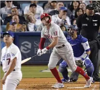  ?? MARK J. TERRILL — THE ASSOCIATED PRESS ?? Phillies’ first baseman Rhys Hoskins watches the flight of his ball that will be a solo home run off Dodgers starter Julio Urias, left, on Saturday in Los Angeles. Looking on are catcher Austin Barnes and umpire Adrian Johnson, right.