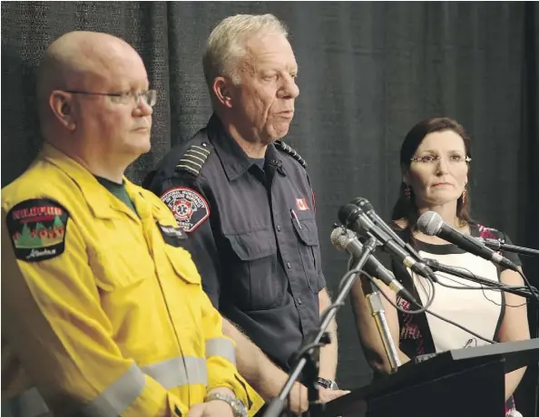  ?? OLIVIA CONDON/POSTMEDIA ?? Alberta Forestry’s Fort McMurray forest area manager Bernie Schmitte, Fire Chief Darby Allen and Mayor Melissa Blake talk to reporters about the state of the wildfire on May 2, 2016. At the time, the fire was coming under control on its edge closest to...