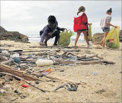  ?? Picture: ALAN EASON ?? ROLLING UP THEIR SLEEVES: Children and adults alike helped in cleaning up the Nahoon coastline between the Nahoon River and Bat’s Cave yesterday morning. The initiative was organised by surfer and environmen­tal educator Dean Knox