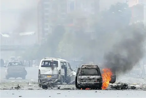  ?? MASSOUD HOSSAINI/THE ASSOCIATED PRESS ?? Smoke rises from a vehicle outside the Afghan parliament in Kabul following the detonation of a deadly car bomb on Monday. The Taliban launched a complex attack as lawmakers were meeting to confirm the appointmen­t of a defence minister.