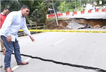  ??  ?? Minister of Domestic Trade and Consumer Affairs Datuk Saifuddin Nasution Ismail, who is also Kulim-Bandar Baharu MP, checks the collapsed bridge. — Bernama photo