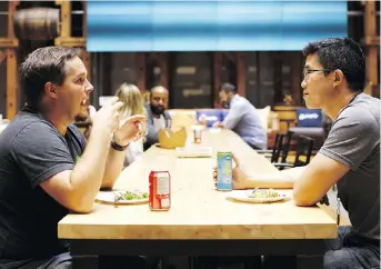  ?? COLE BURSTON/BLOOMBERG ?? Employees eat in a common area at the Shopify Inc. office in Waterloo, Ont. Shopify Plus, the company’s highesttie­red subscripti­on, is attracting migrations from other platforms.