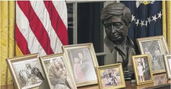  ?? ALEX BRANDON/AP ?? The sculpture of Cesar Chavez among Biden family photos in the Oval Office.