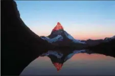  ?? ASSOCIATED PRESS ?? Mount Matterhorn glows in the last rays of the day as it is reflected in Lake Riffelsee in the Swiss Alps near Zermatt, Switzerlan­d in this undated photo. The sheer majesty of the mountain - described back in the mid-19th century as “the peak people...