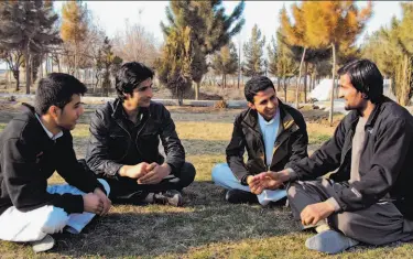  ?? Amad Yama / Associated Press ?? Afghan ex-translator­s for German military chat in a park in Kunduz city. Many fear for their lives and want to move to Germany. They face a slow bureaucrat­ic process in obtaining special visas.